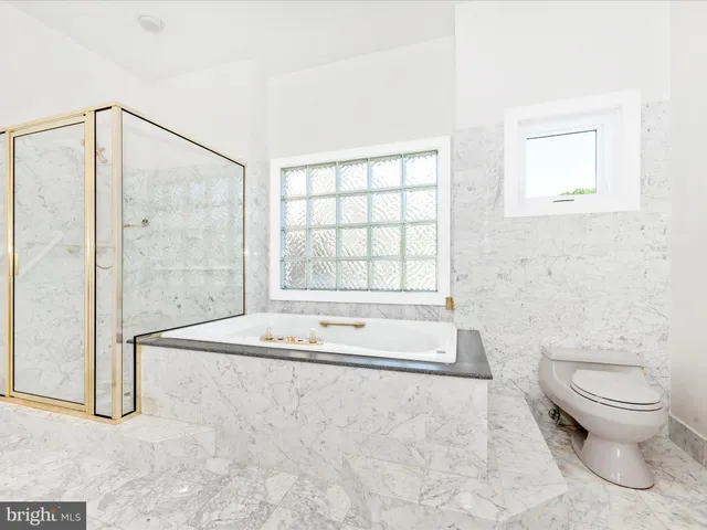 a view of a swimming pool with an outdoor seating and trees in the background