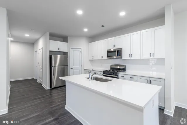 a kitchen with refrigerator cabinets and wooden floor
