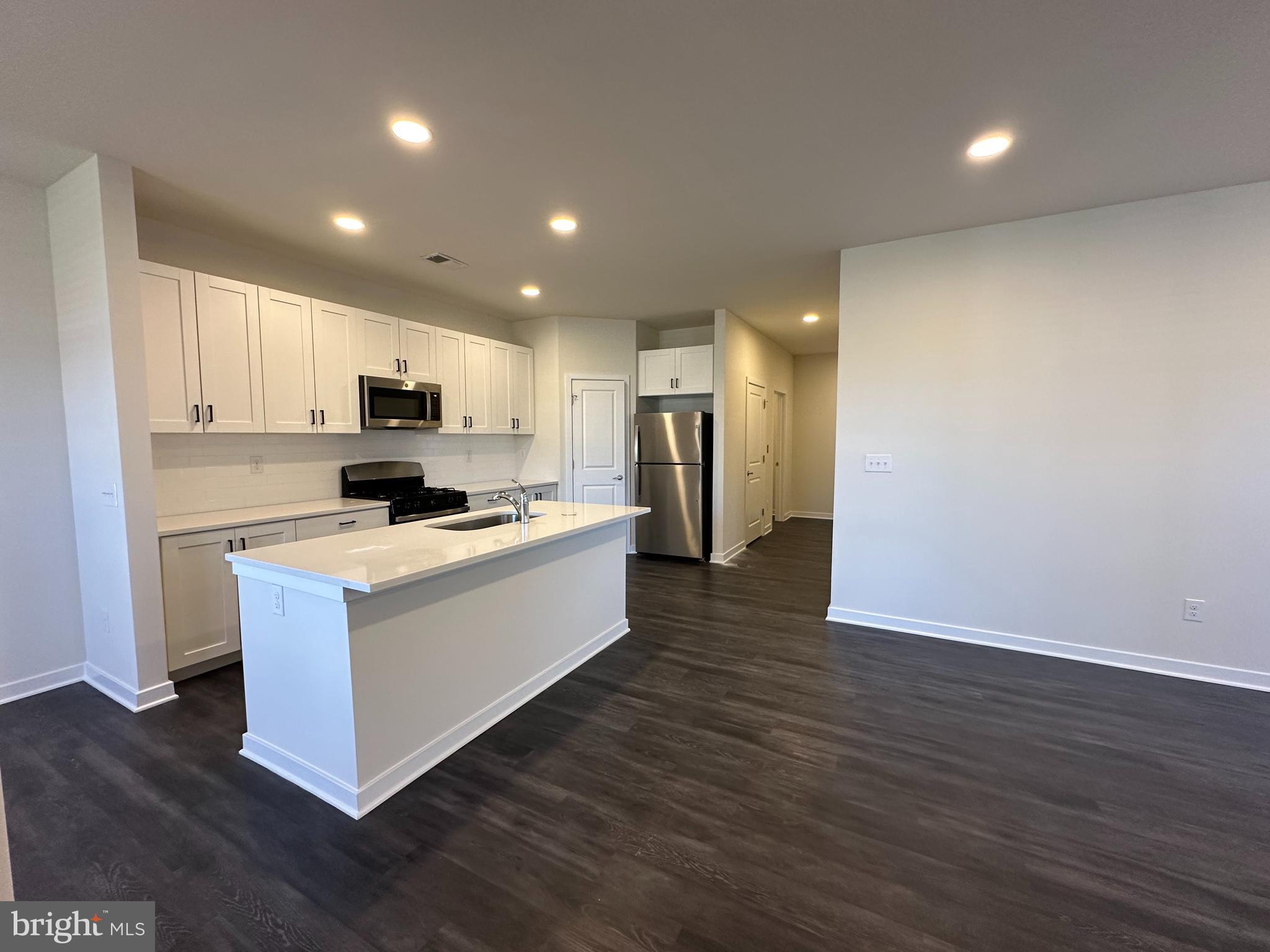 511 Nickerjack Way Dover, DE 19904 - Photo 3 of 7 a large kitchen with kitchen island a sink dishwasher a refrigerator and a stove with wooden floor