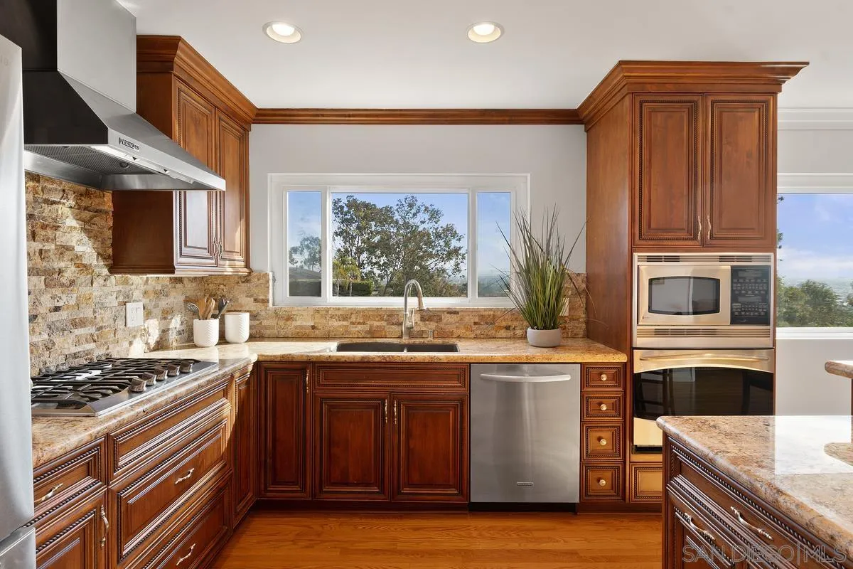 5629 Soledad Road La Jolla, CA 92037 - Photo 18 of 38 a kitchen with stainless steel appliances granite countertop a stove and a sink