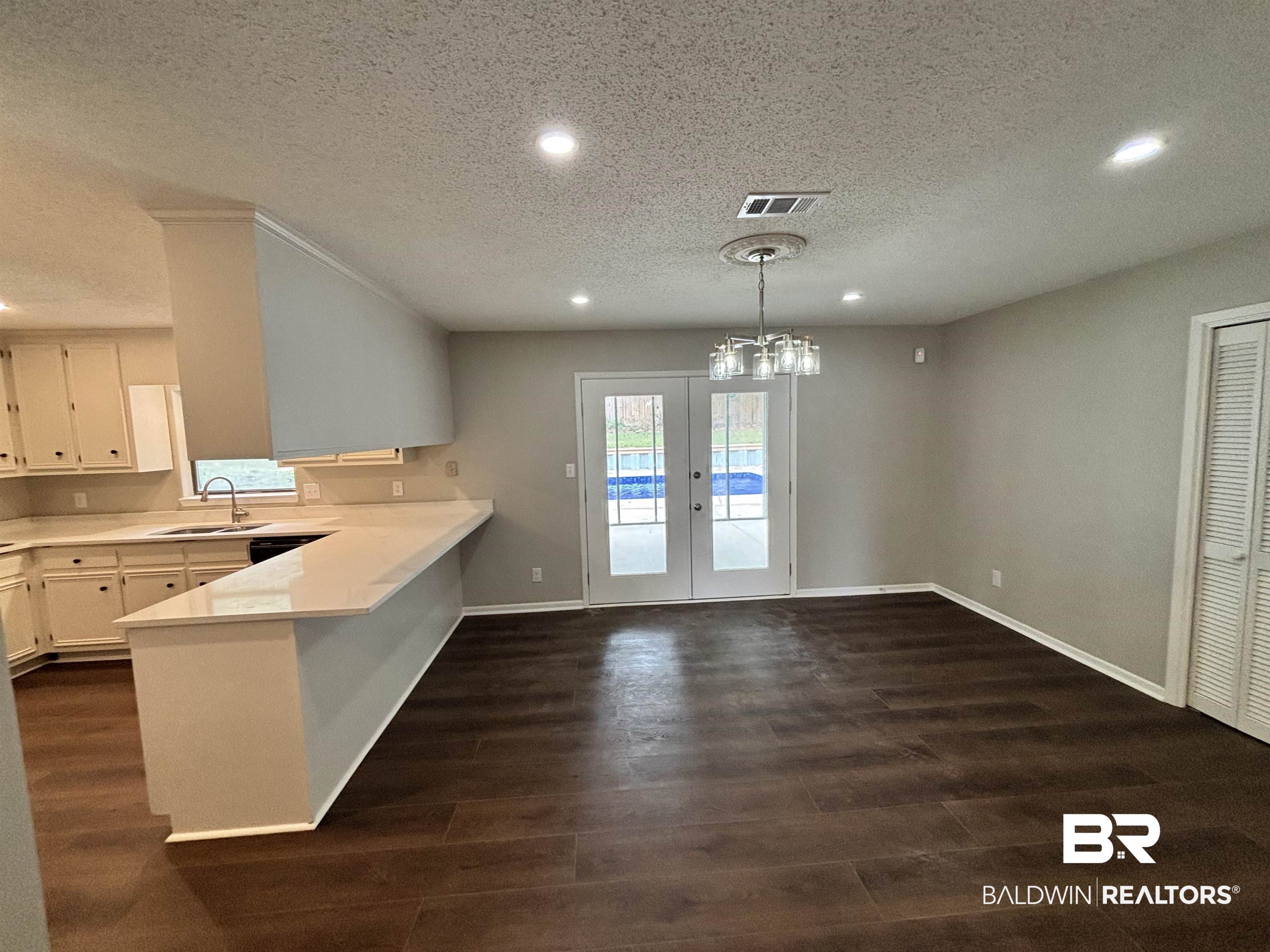 10 Soldiers Route Daphne, AL 36527 - Photo 7 of 26 Kitchen with light countertops, a peninsula, a textured ceiling, recessed lighting, and french doors
