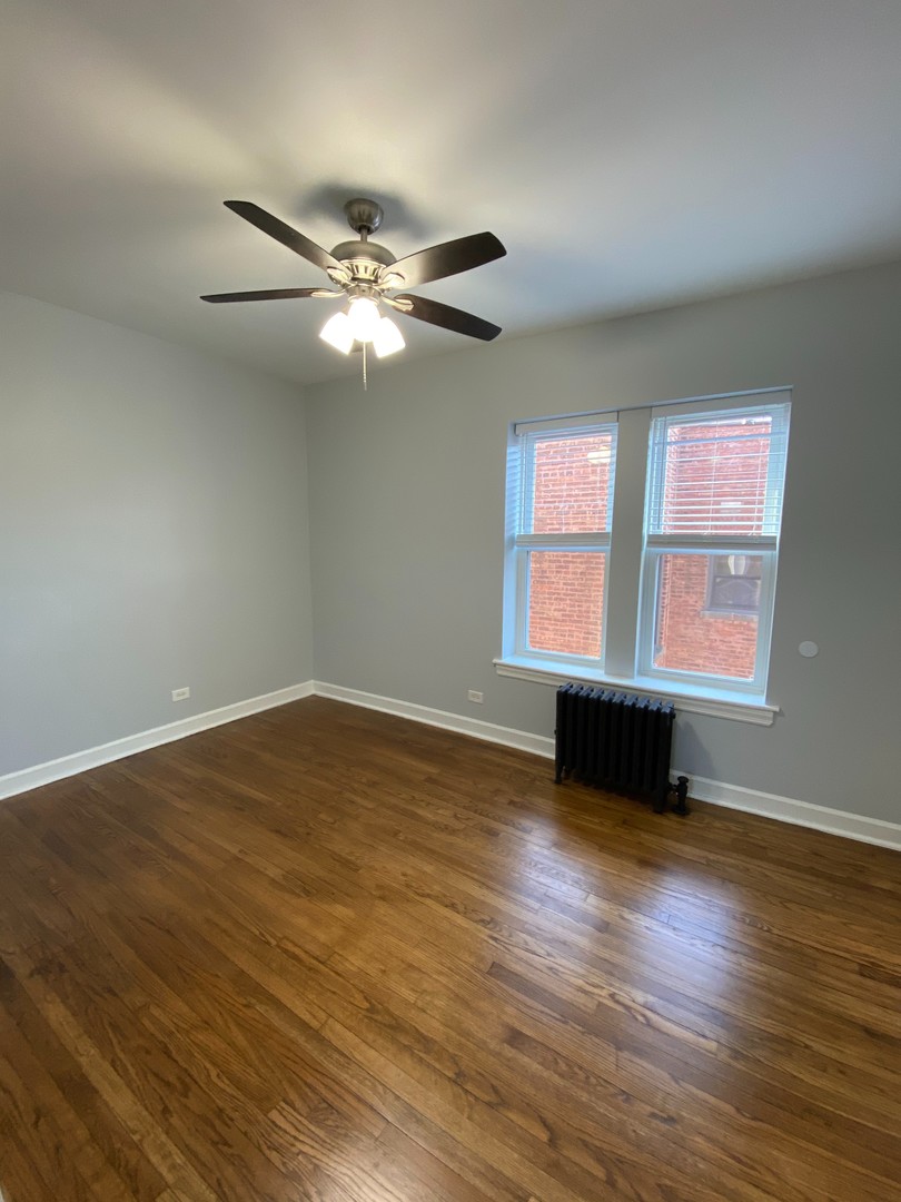 1722 West Juneway Terrace, Unit 3B Chicago, IL 60626 - Photo 5 of 9 a view of an empty room with wooden floor and a window