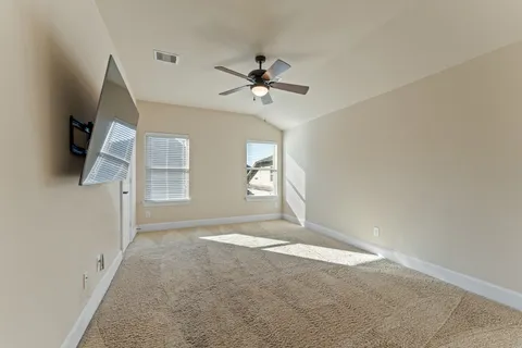 an empty room with windows and fan