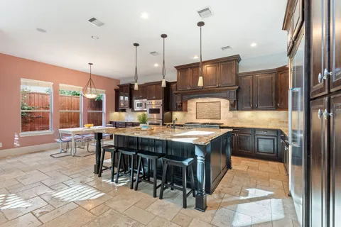 a kitchen with kitchen island granite countertop wooden cabinets a counter top and stainless steel appliances