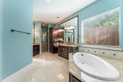 a bathroom with a tub sink and mirror