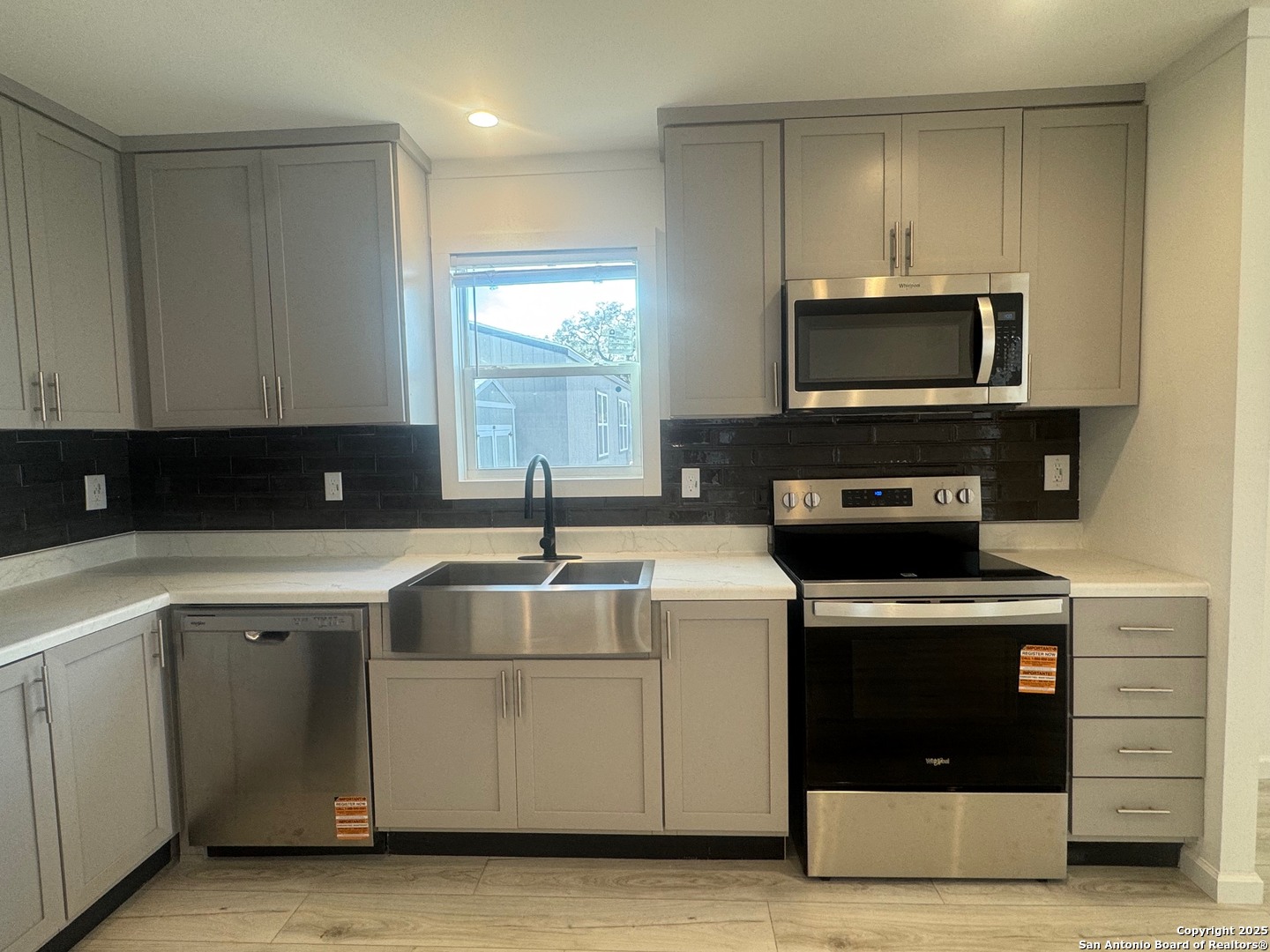 213 West White Street Pleasanton, TX 78064 - Photo 2 of 7 a kitchen with stainless steel appliances granite countertop a stove a microwave and a sink