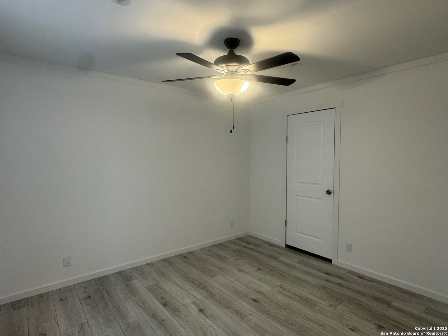 213 West White Street Pleasanton, TX 78064 - Photo 4 of 7 a view of an empty room with wooden floor