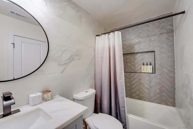 a kitchen with stainless steel appliances white cabinets and a stove a refrigerator a sink