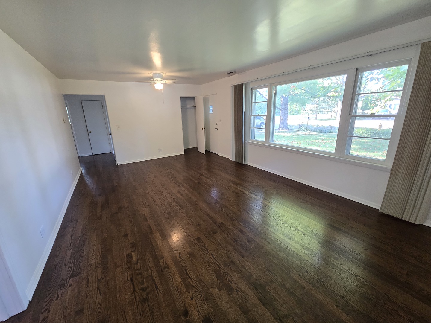 901 East Krage Drive Addison, IL 60101 - Photo 5 of 25 a view of an empty room with wooden floor and a window
