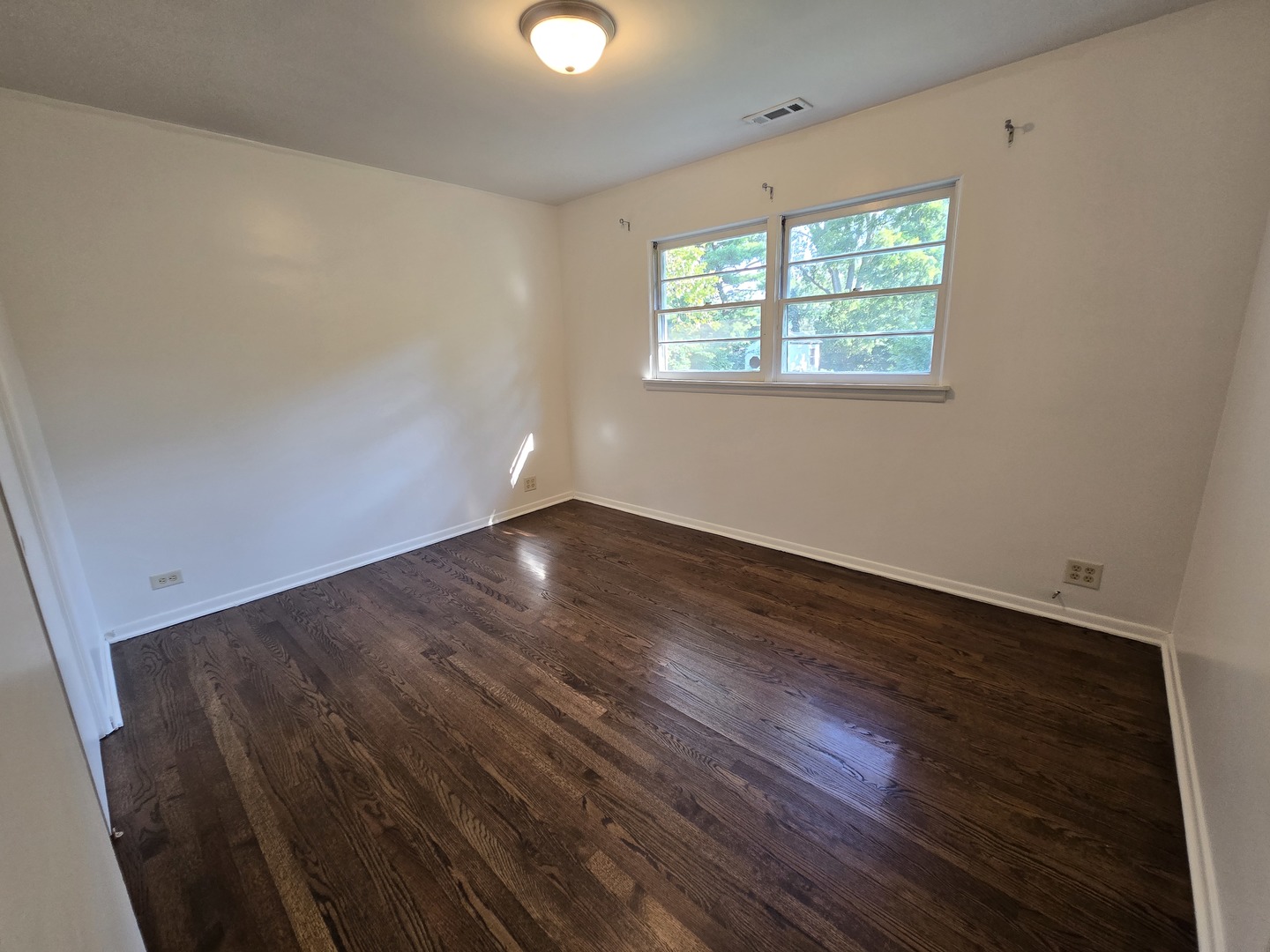 901 East Krage Drive Addison, IL 60101 - Photo 8 of 25 an empty room with wooden floor and windows
