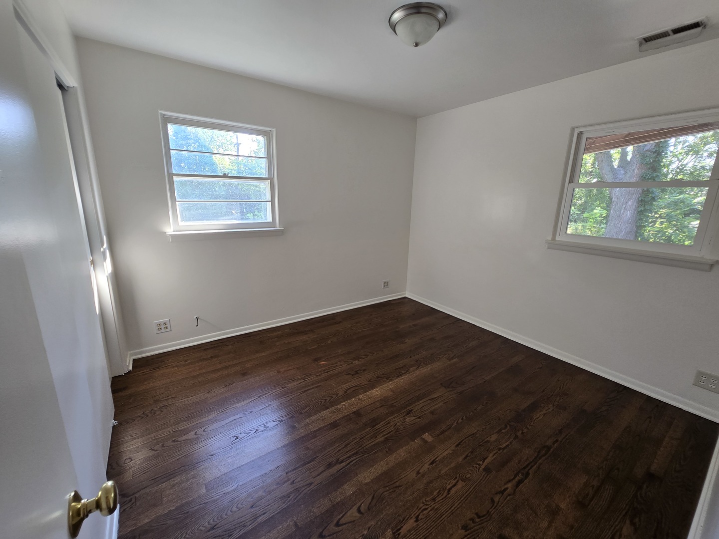 901 East Krage Drive Addison, IL 60101 - Photo 10 of 25 an empty room with wooden floor and windows