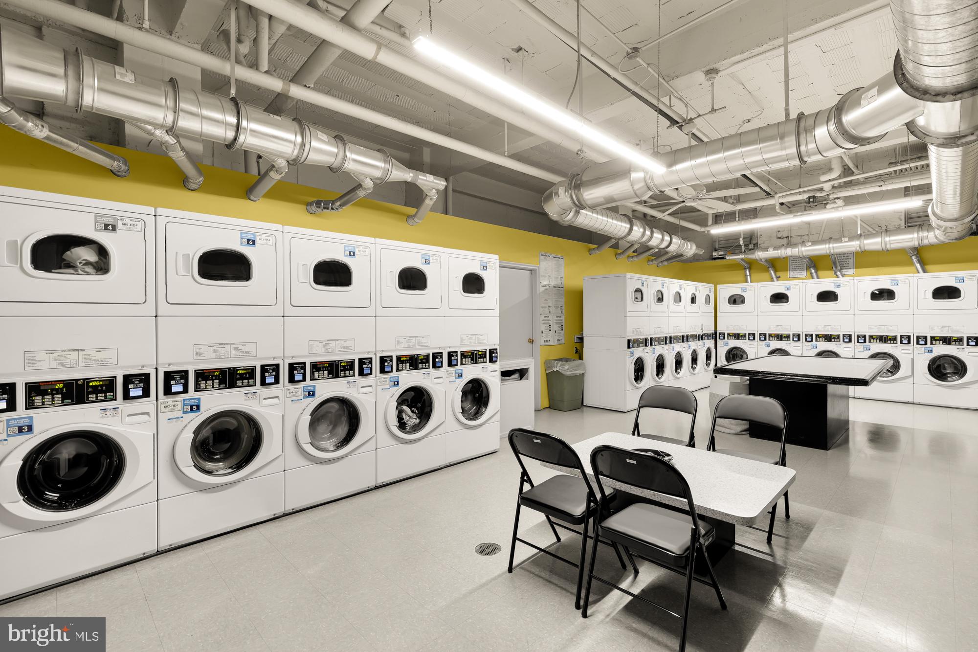 2040 Belmont Road Northwest, Unit 628 Washington, DC 20009 - Photo 17 of 19 a kitchen with a stove a microwave a dining table and chairs with the red carpet