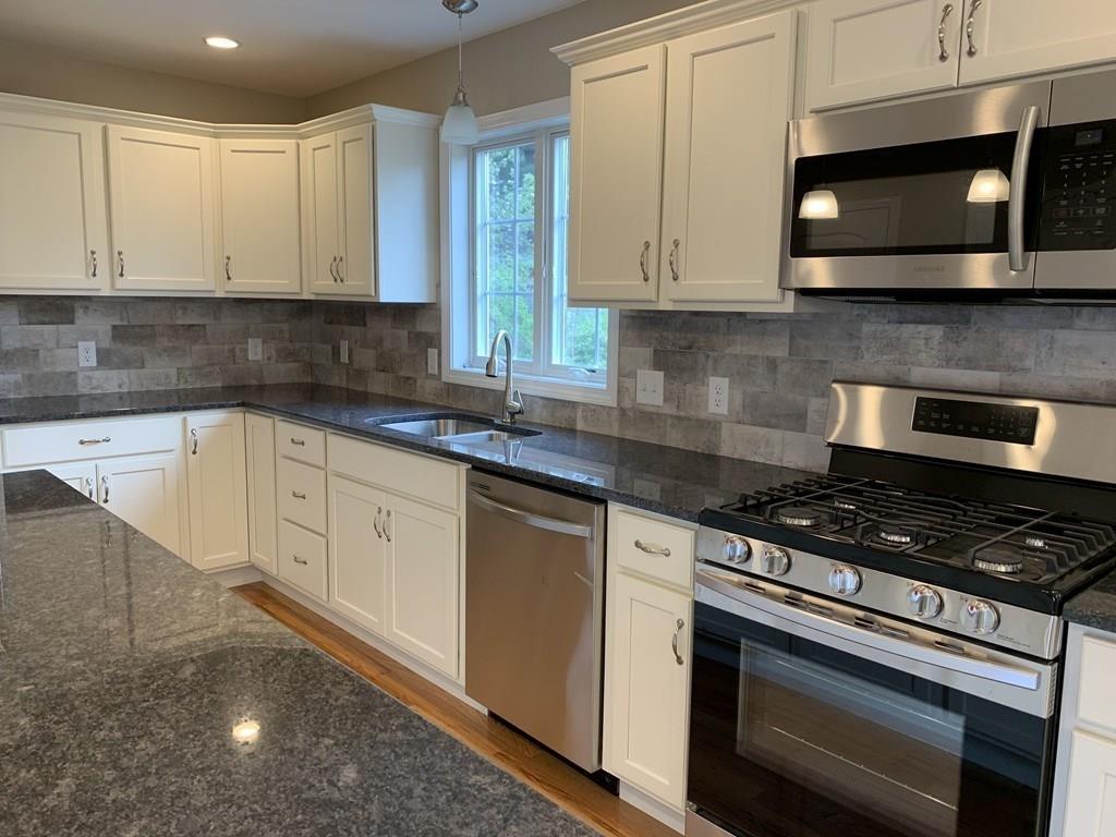 45 Delaware Avenue Springfield, MA 01119 - Photo 3 of 19 a kitchen with stainless steel appliances granite countertop grey cabinets a stove a sink and dishwasher