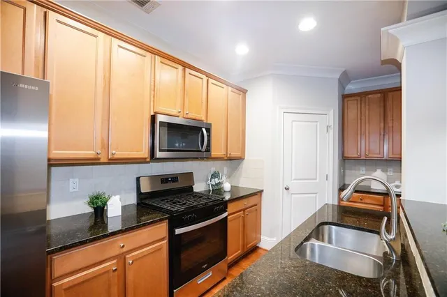 a kitchen with a sink a stove and a microwave