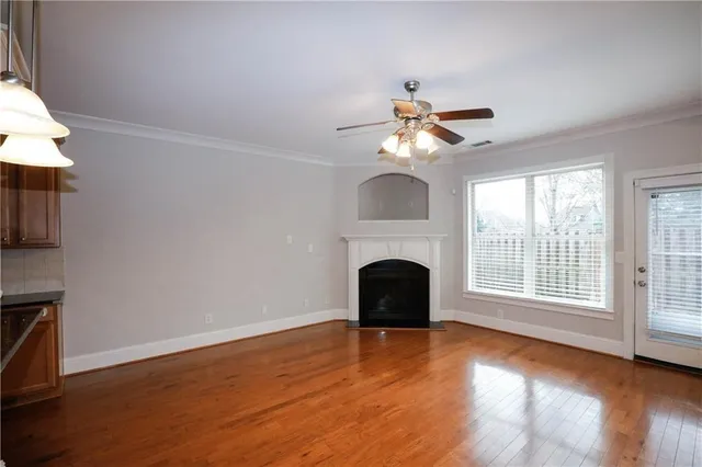 a view of empty room with fireplace and wooden floor