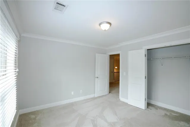 an empty room with closet and a window