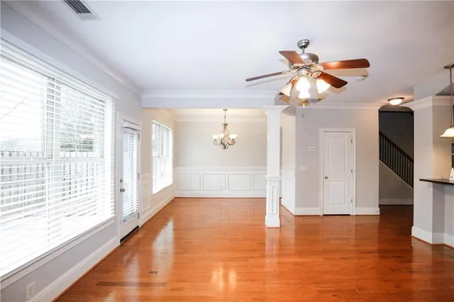 a view of a livingroom with wooden floor and a ceiling fan