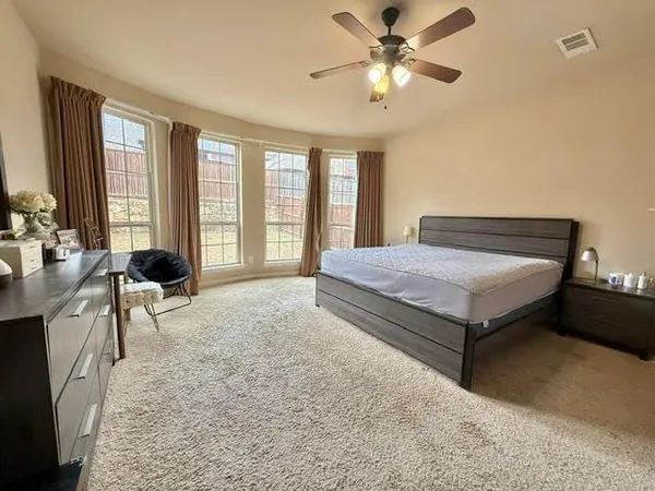 a spacious bedroom with a bed and a chandelier
