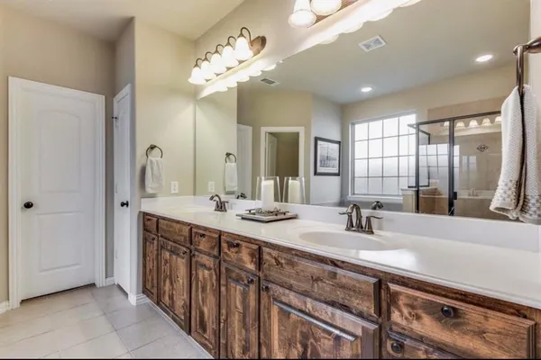 a bathroom with double vanity sinks and a mirror