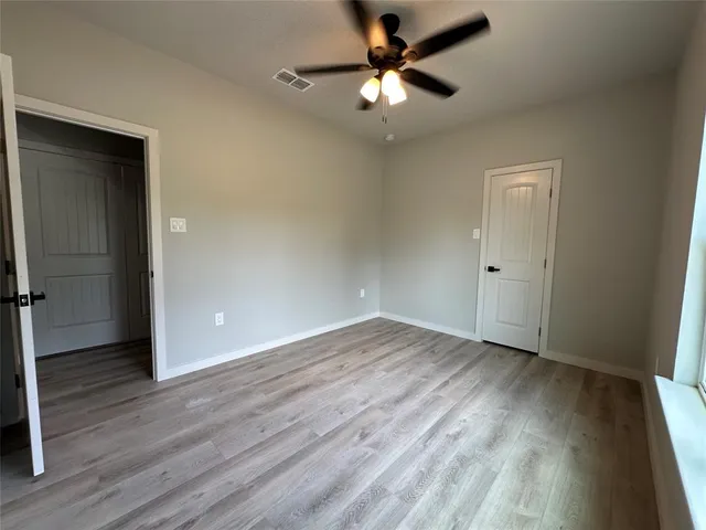 an empty room with a window and wooden floor