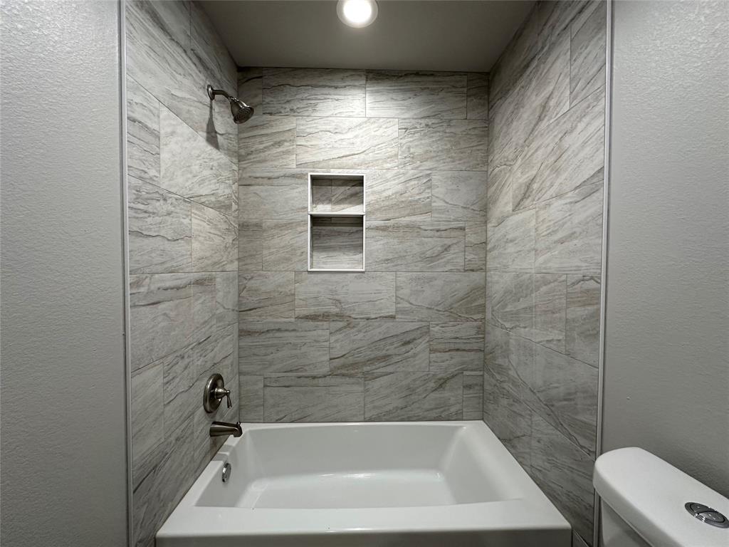 317 North Clark Street Comanche, TX 76442 - Photo 19 of 35 a bathroom with a bathtub and a shower