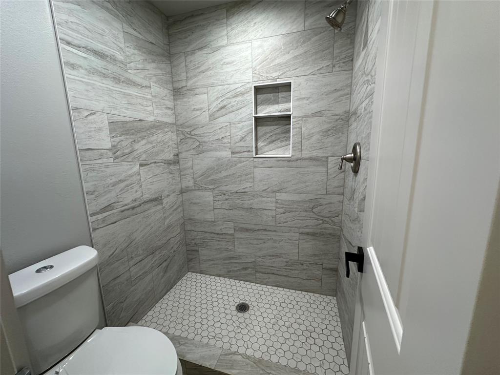 317 North Clark Street Comanche, TX 76442 - Photo 25 of 35 a bathroom with a toilet and a shower
