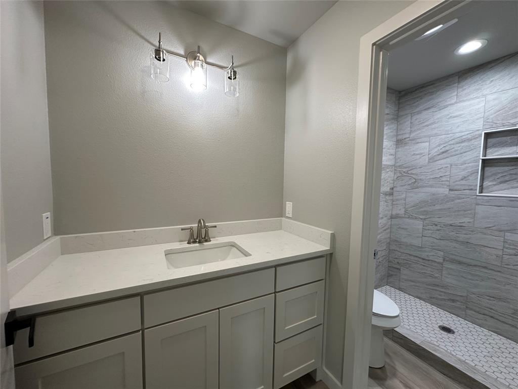 317 North Clark Street Comanche, TX 76442 - Photo 28 of 35 a bathroom with a sink a toilet and shower