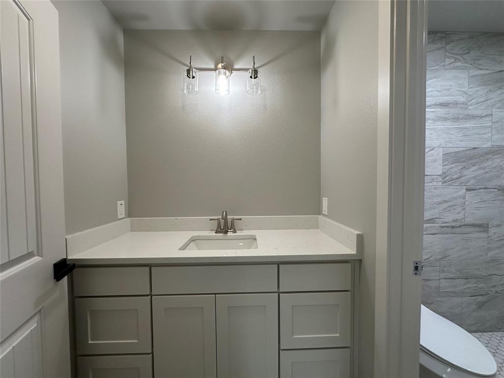 317 North Clark Street Comanche, TX 76442 - Photo 29 of 35 a bathroom with a sink and a mirror
