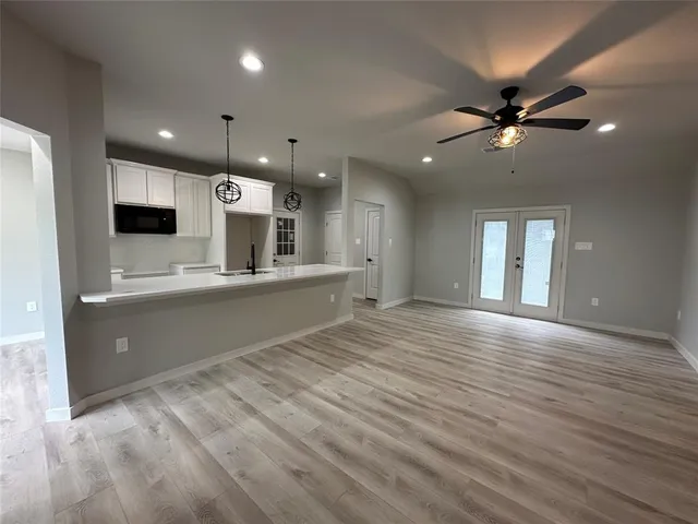 a kitchen with counter top space stainless steel appliances and wooden floor