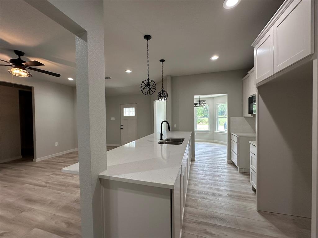 317 North Clark Street Comanche, TX 76442 - Photo 5 of 35 a kitchen with counter top space stainless steel appliances and wooden floor