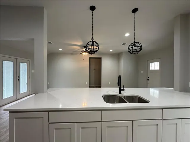 a kitchen with stainless steel appliances granite countertop a sink and a stove top oven with wooden floor
