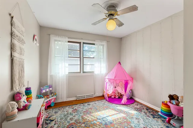 a view of play room with toys and ceiling fan
