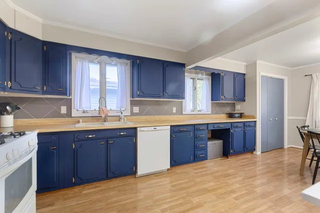 a kitchen with a sink stove and wooden cabinets