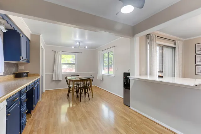 a dining room with wooden floor and stainless steel appliances