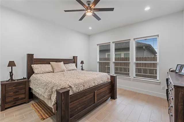 a bedroom with a bed a dresser and a chandelier