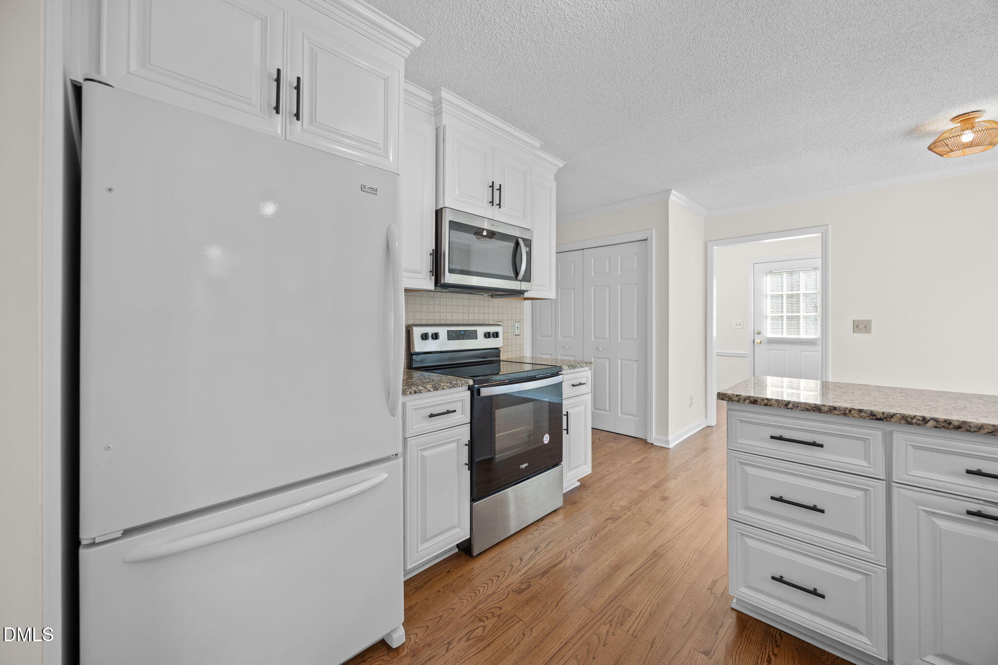 102 Korbel Place Cary, NC 27513 - Photo 13 of 43 a kitchen with granite countertop white cabinets and stainless steel appliances