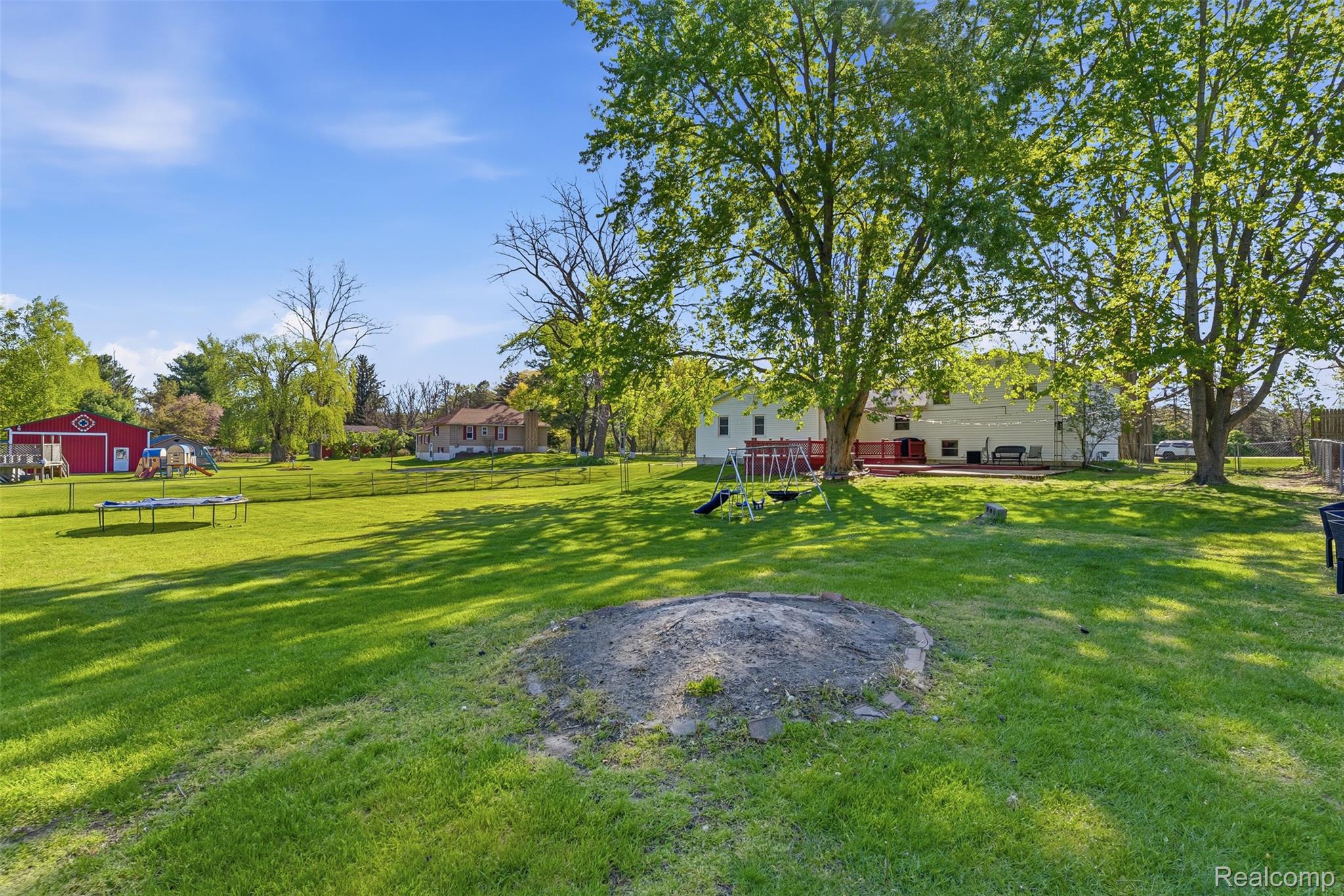 14433 Tuscola Road Clio, MI 48420 - Photo 35 of 43 Fenced backyard featuring a trampoline and a playground