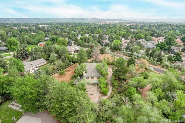 an aerial view of residential houses with outdoor space and trees