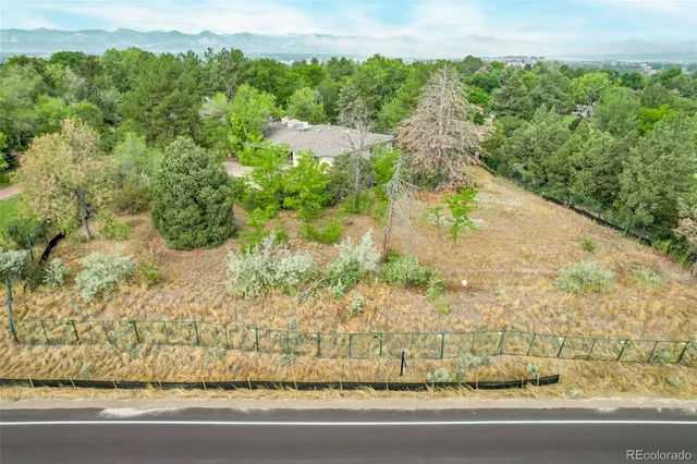 an aerial view of residential house with outdoor space and trees all around