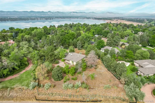 an aerial view of residential houses with outdoor space and trees