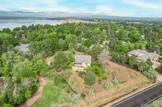 an aerial view of residential houses with outdoor space and trees