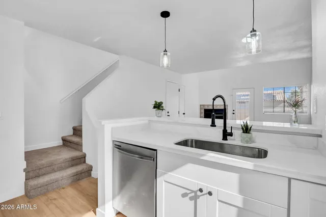 a kitchen with kitchen island a sink stainless steel appliances and a counter top space