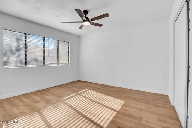 a view of a big room with wooden floor and windows