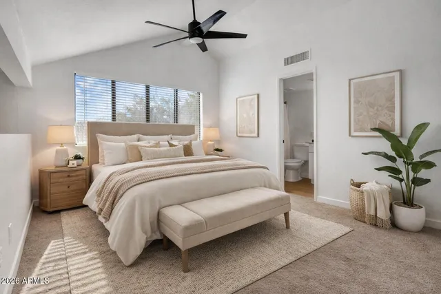 a bedroom with a large bed and a chandelier