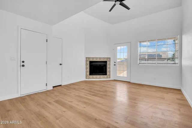 a view of an empty room with a window and a fireplace