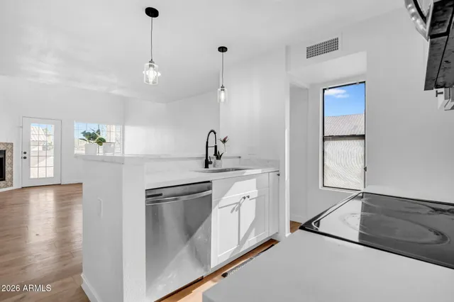 a kitchen with stainless steel appliances granite countertop a sink a stove and a refrigerator