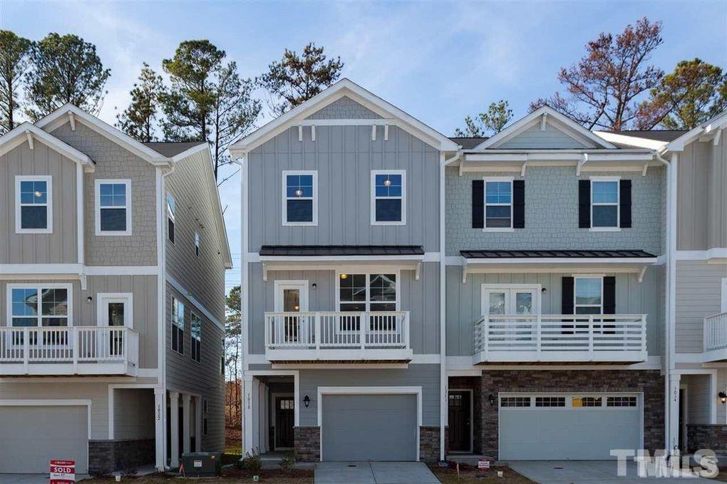 a front view of a house with a tree
