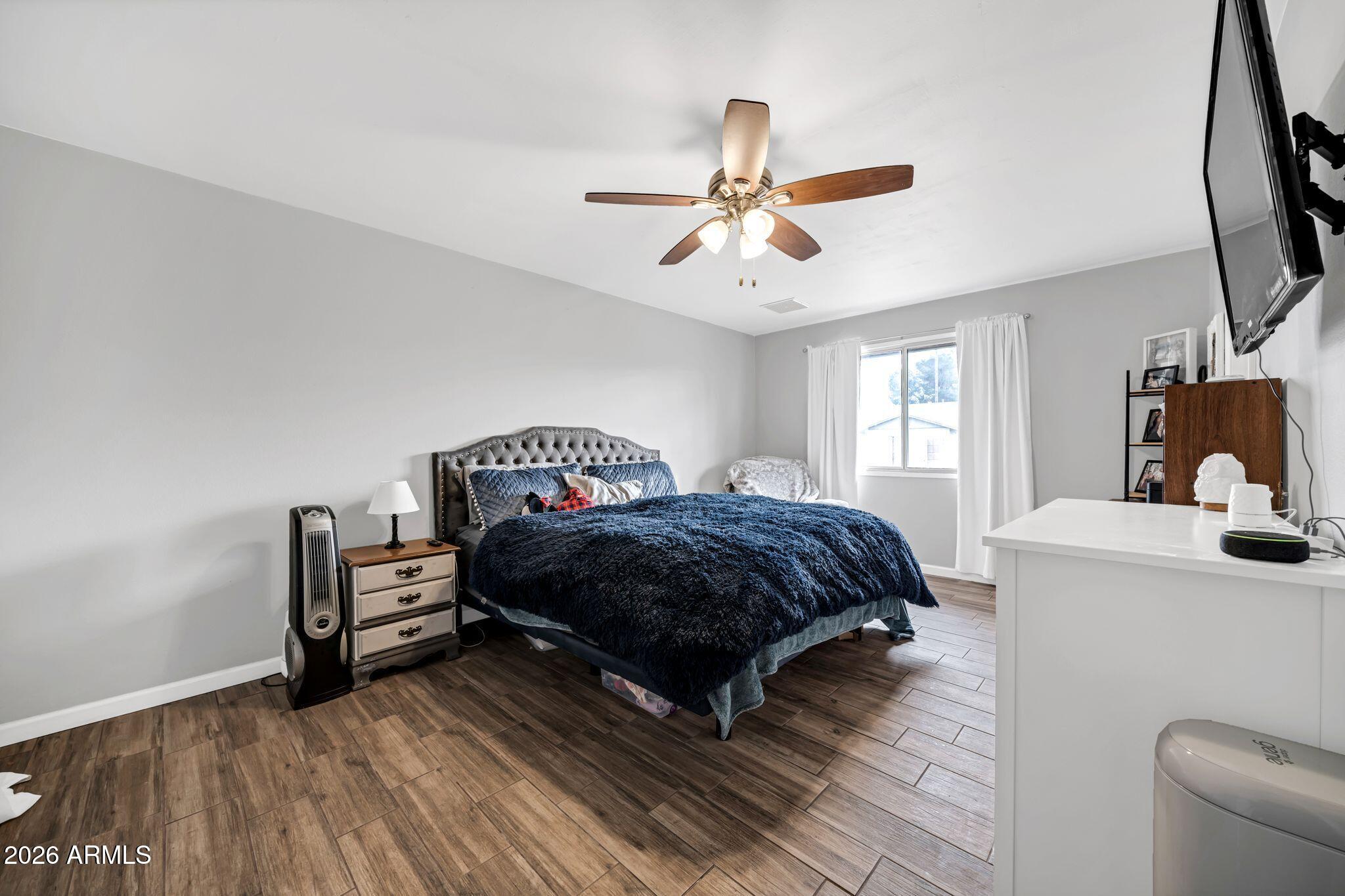 3041 West Acoma Drive Phoenix, AZ 85053 - Photo 12 of 35 a bedroom with a bed and wooden floor