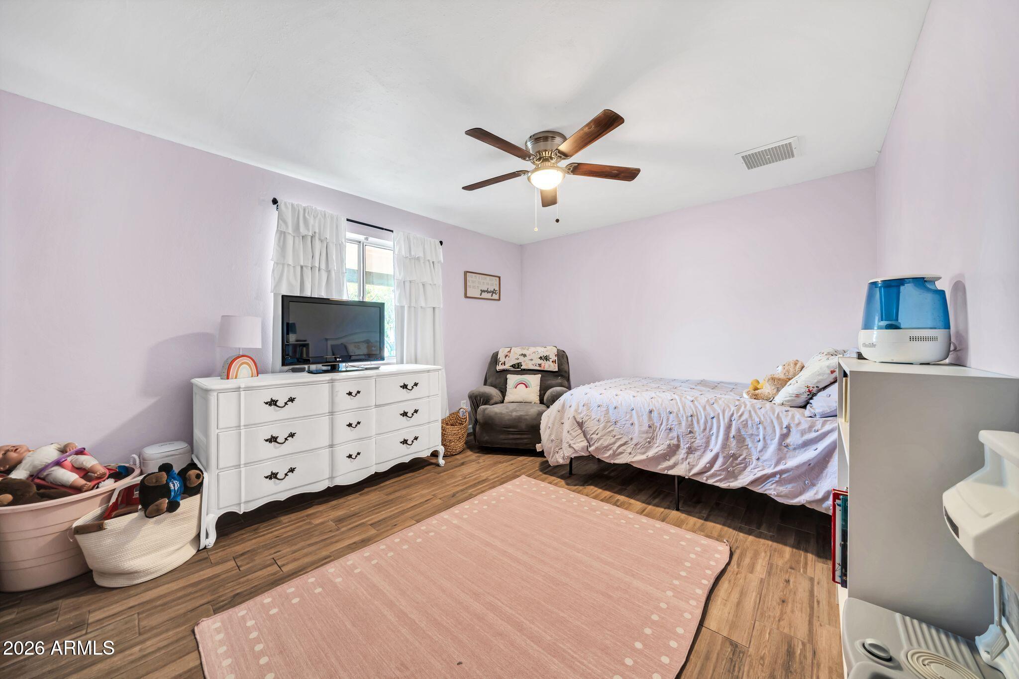 3041 West Acoma Drive Phoenix, AZ 85053 - Photo 17 of 35 a bedroom with furniture and a flat screen tv