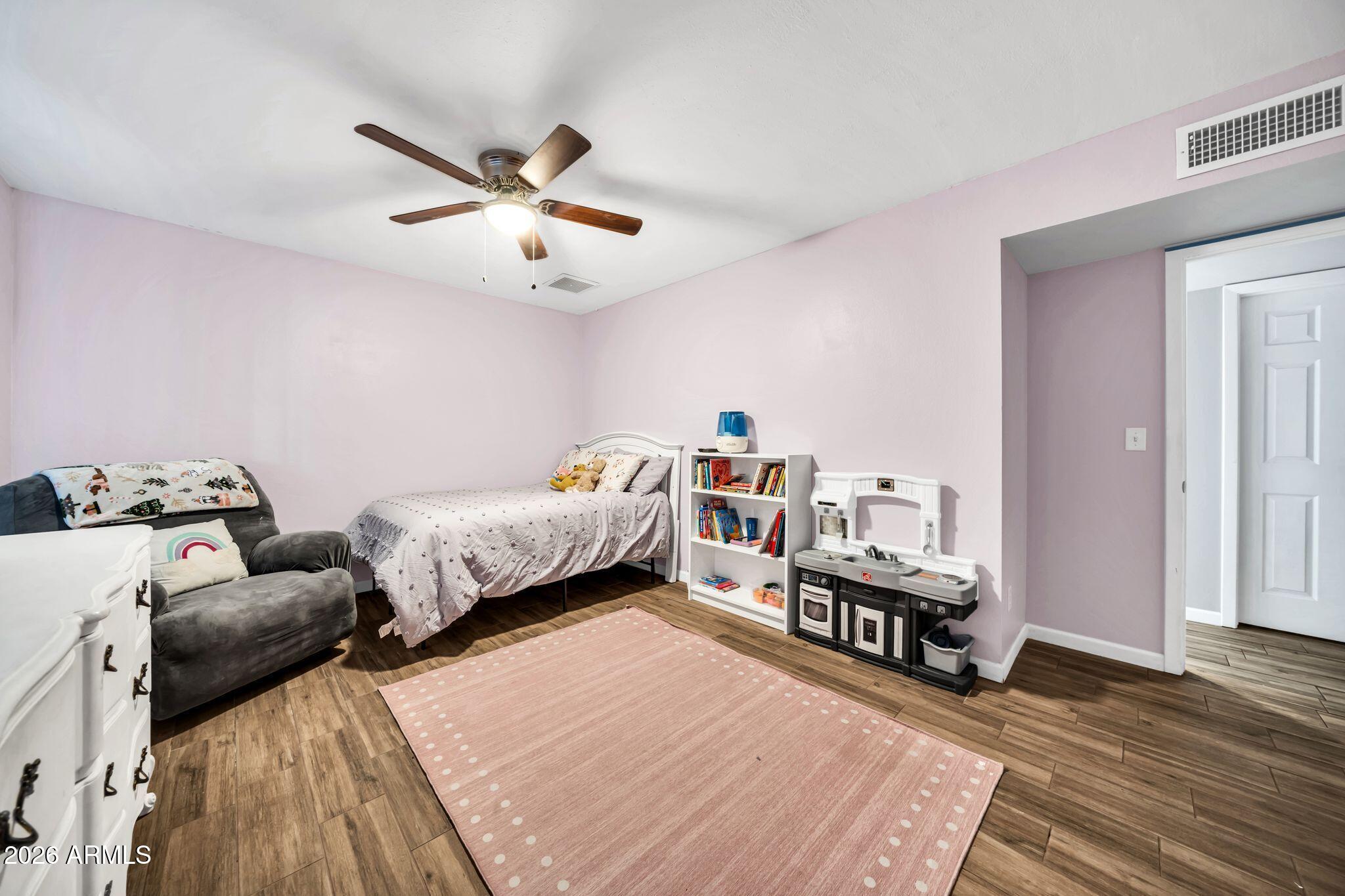 3041 West Acoma Drive Phoenix, AZ 85053 - Photo 18 of 35 a bed room with bed and a chandelier